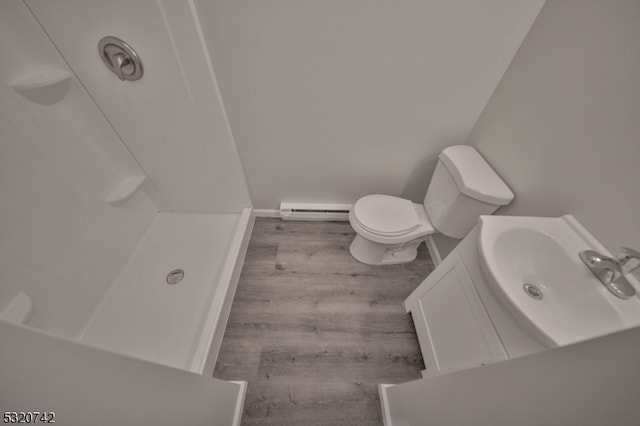 bathroom with a baseboard radiator, hardwood / wood-style floors, toilet, vanity, and a shower