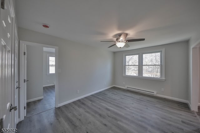 spare room with hardwood / wood-style flooring, a healthy amount of sunlight, and baseboard heating