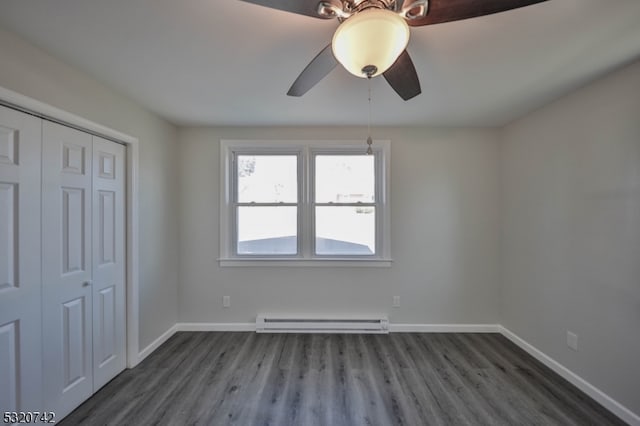 unfurnished bedroom with a baseboard heating unit, ceiling fan, a closet, and dark hardwood / wood-style flooring