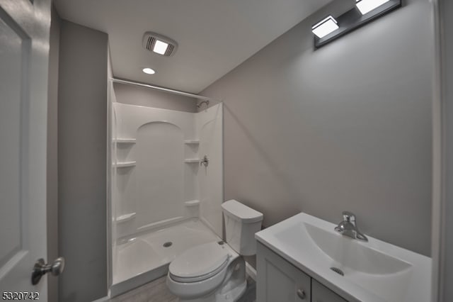 bathroom featuring vanity, toilet, and a shower