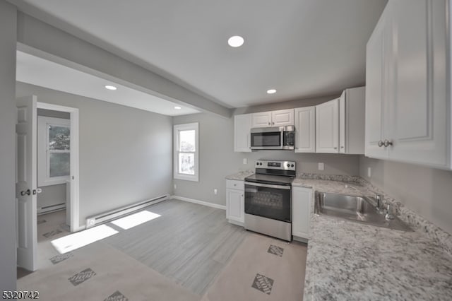 kitchen featuring a baseboard heating unit, white cabinets, sink, light hardwood / wood-style floors, and stainless steel appliances