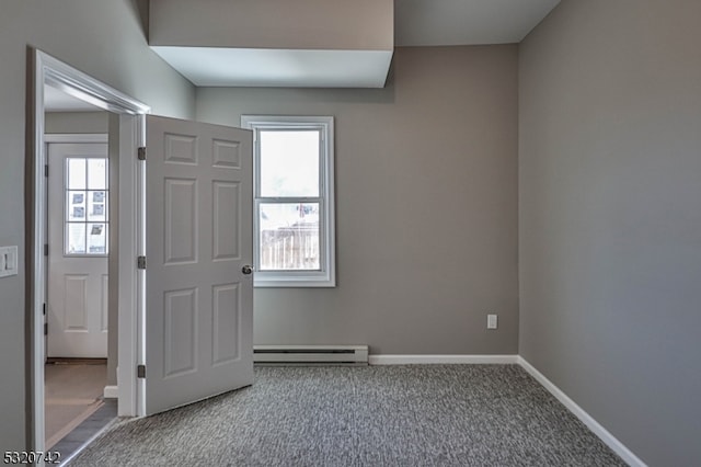 carpeted empty room with baseboard heating