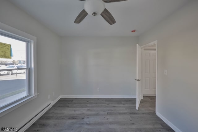 empty room featuring a baseboard heating unit, hardwood / wood-style floors, and ceiling fan