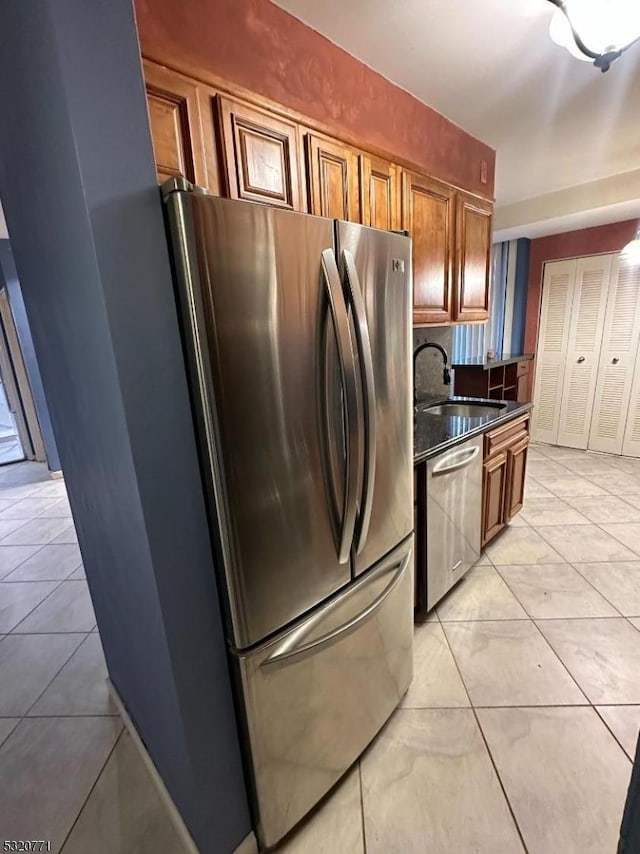 kitchen featuring tasteful backsplash, sink, light tile patterned flooring, and appliances with stainless steel finishes