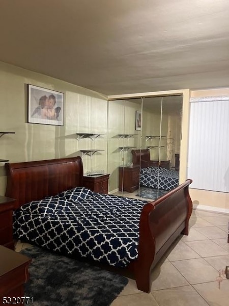 bedroom featuring light tile patterned floors and a closet