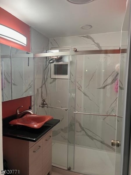 bathroom featuring vanity and a shower with door