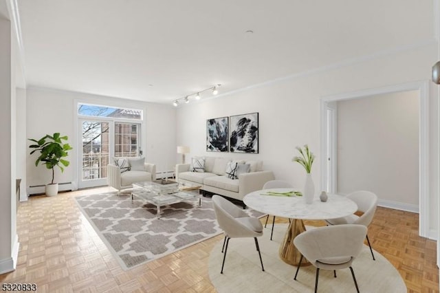 living room with light parquet flooring, crown molding, and baseboard heating