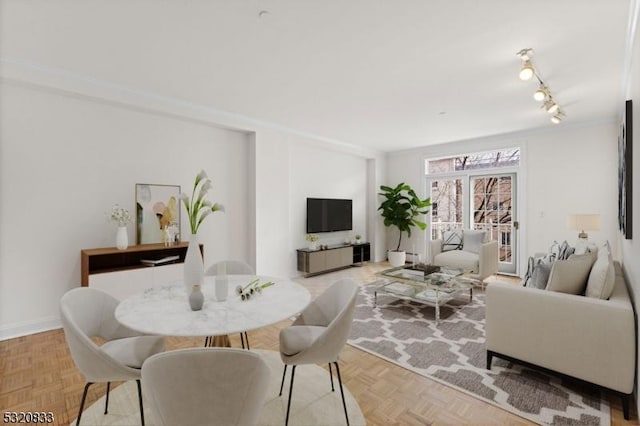 dining space featuring light parquet floors and rail lighting