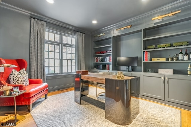 office area featuring crown molding, built in features, and light wood-type flooring