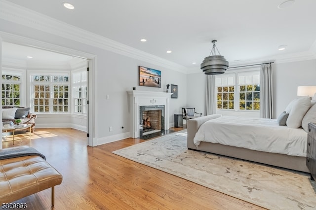 bedroom featuring ornamental molding, light hardwood / wood-style flooring, and multiple windows