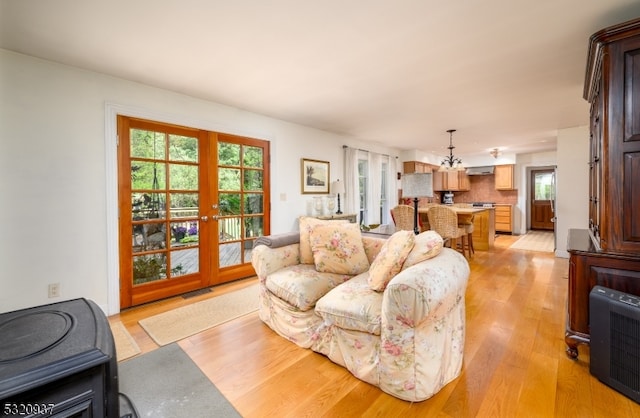 living room featuring heating unit, french doors, and light wood-type flooring