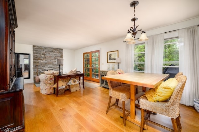 dining space featuring light hardwood / wood-style flooring and a chandelier