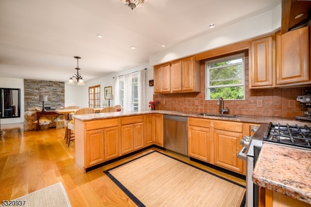 kitchen featuring pendant lighting, backsplash, sink, and stainless steel appliances