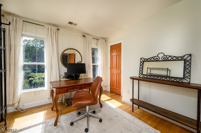 home office with light hardwood / wood-style floors