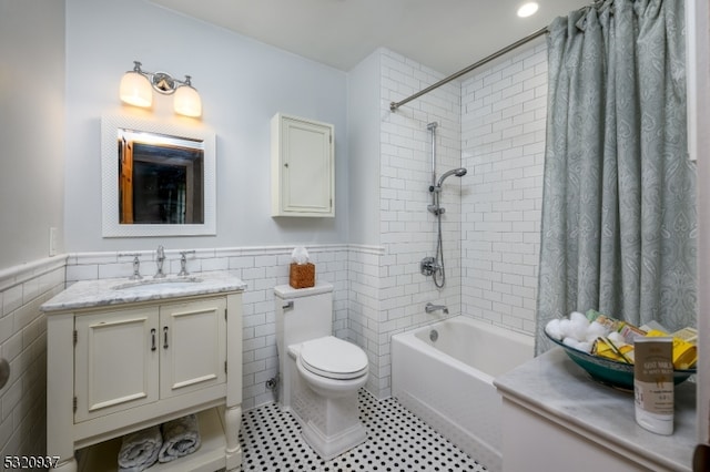 full bathroom with vanity, tile patterned floors, shower / bath combination with curtain, toilet, and tile walls