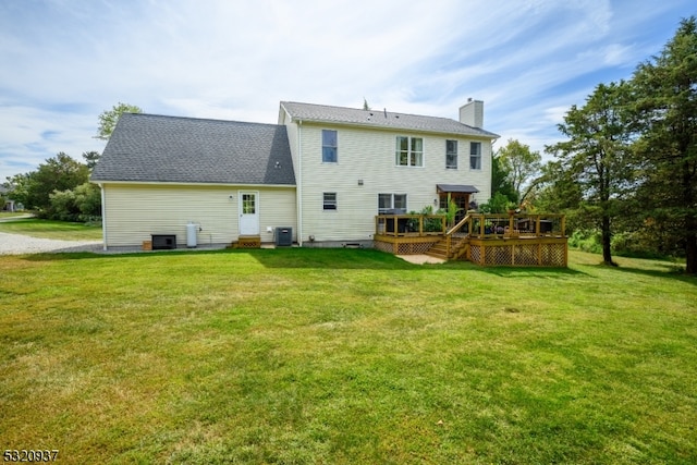 back of house with a lawn, central AC unit, and a deck