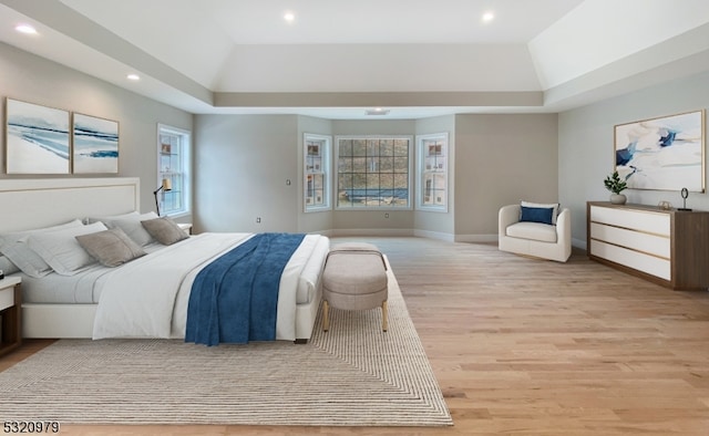 bedroom featuring light hardwood / wood-style floors and vaulted ceiling