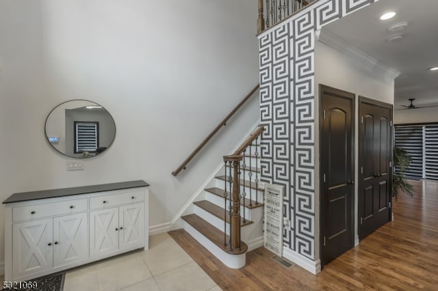 staircase featuring ornamental molding, hardwood / wood-style flooring, and ceiling fan