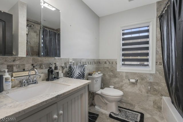 full bathroom featuring toilet, shower / tub combo, vanity, and tile walls