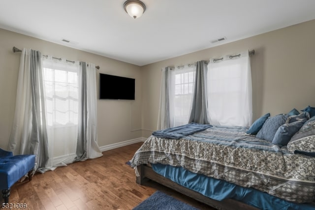 bedroom featuring wood-type flooring and multiple windows