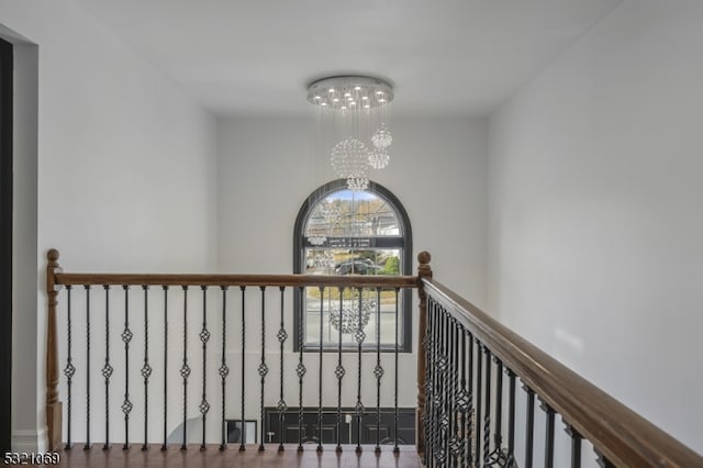 hallway featuring an inviting chandelier and hardwood / wood-style flooring