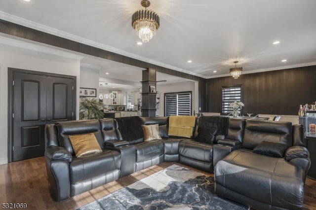 cinema room with crown molding, an inviting chandelier, and dark hardwood / wood-style flooring