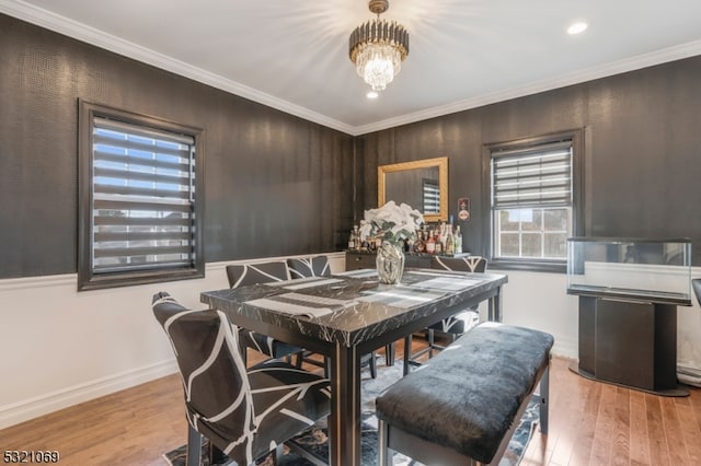 dining space featuring light wood-type flooring and ornamental molding