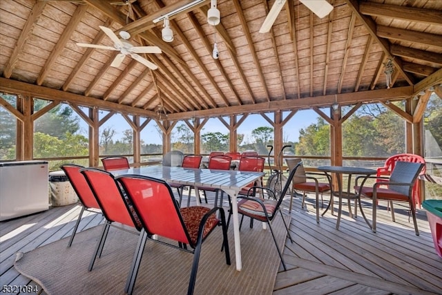 sunroom / solarium with ceiling fan, wooden ceiling, and vaulted ceiling with beams