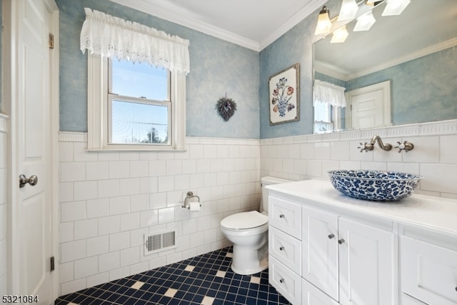 bathroom with tile walls, vanity, crown molding, and toilet