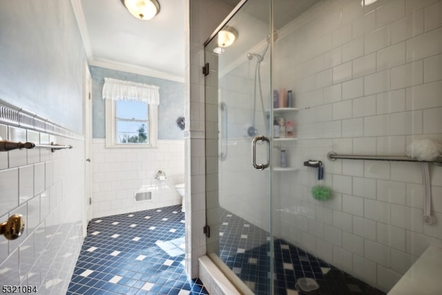 bathroom featuring ornamental molding, a shower with shower door, tile walls, and tile patterned flooring