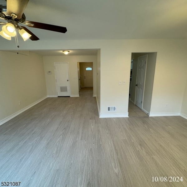 unfurnished room featuring light hardwood / wood-style flooring and ceiling fan