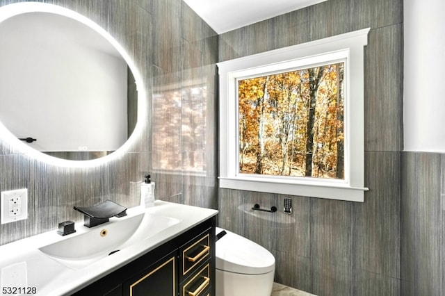 bathroom with vanity, tile walls, and toilet