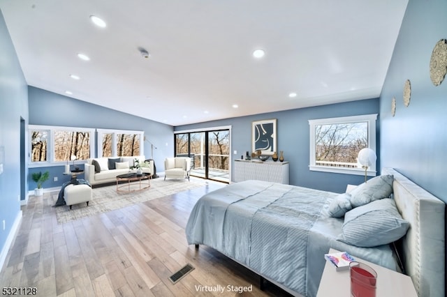 bedroom with vaulted ceiling and light wood-type flooring