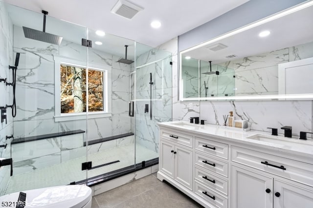 bathroom with tile walls, vanity, a shower with shower door, and toilet