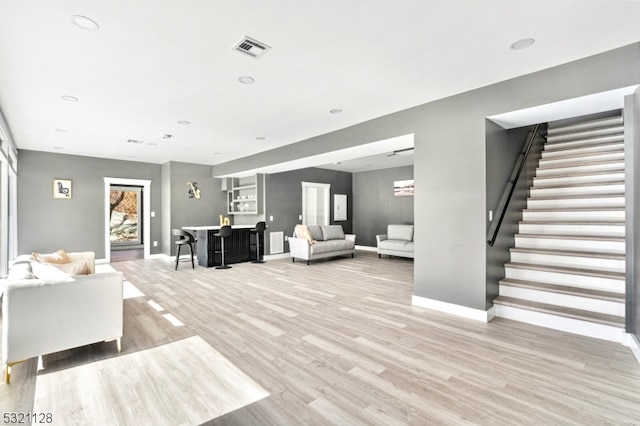 living room featuring bar and light hardwood / wood-style floors