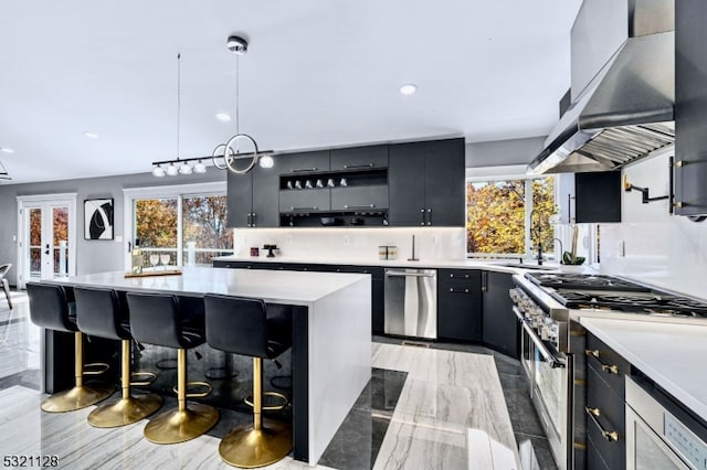 kitchen featuring backsplash, pendant lighting, high end stainless steel range oven, and extractor fan