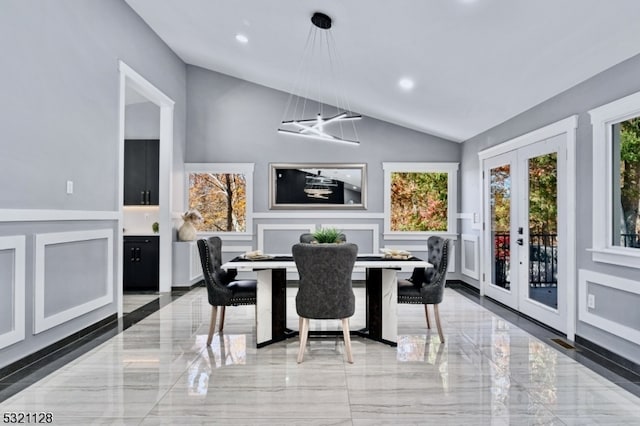 dining room with french doors, vaulted ceiling, and a notable chandelier