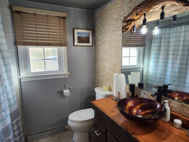 bathroom with a shower with curtain, vanity, a baseboard heating unit, tile patterned floors, and toilet