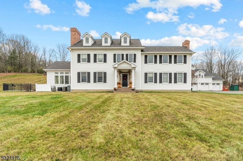 colonial-style house featuring a front lawn