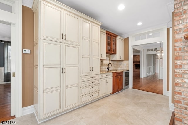 kitchen featuring backsplash, wine cooler, cream cabinets, and light hardwood / wood-style floors