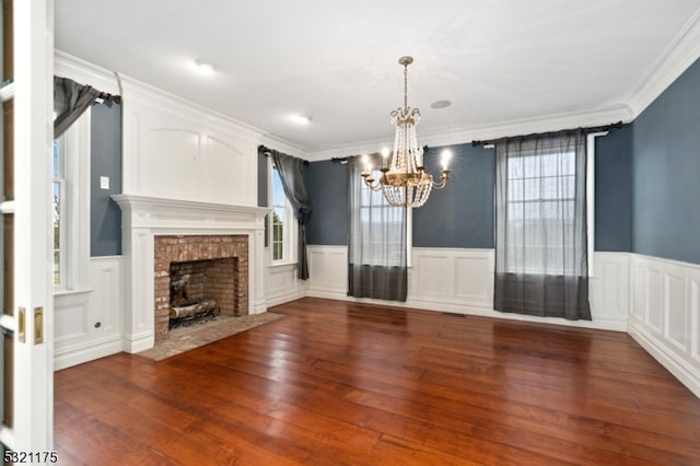 unfurnished living room featuring ornamental molding, dark wood-type flooring, and a brick fireplace