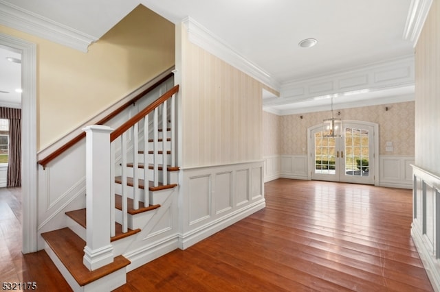 staircase with hardwood / wood-style flooring, a healthy amount of sunlight, and ornamental molding