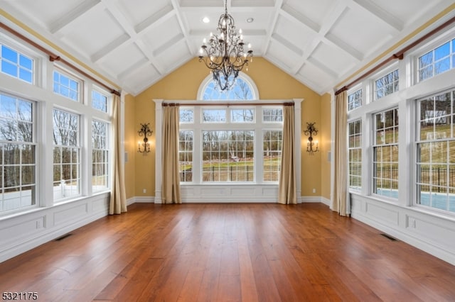 unfurnished sunroom featuring beam ceiling, plenty of natural light, and a notable chandelier