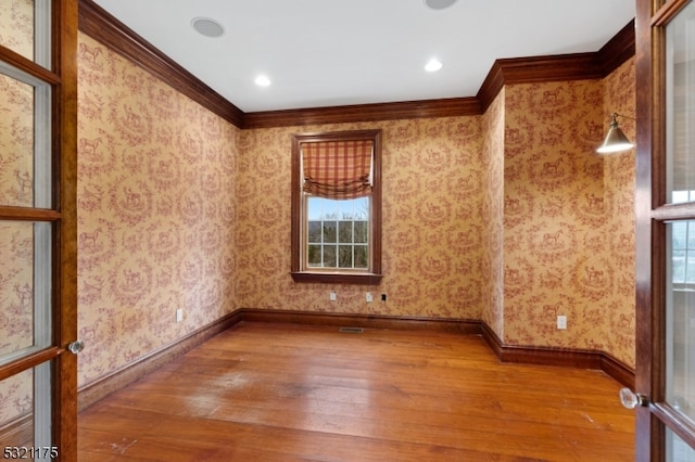 unfurnished room featuring crown molding and hardwood / wood-style flooring