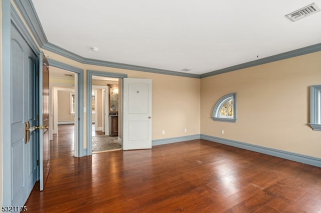 spare room featuring crown molding and dark hardwood / wood-style floors