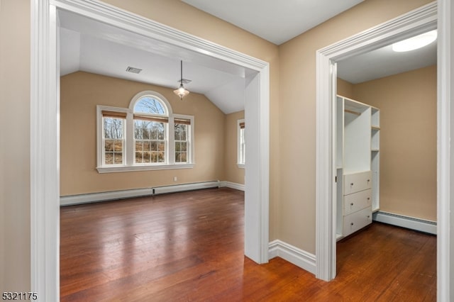 interior space featuring dark hardwood / wood-style floors, vaulted ceiling, and baseboard heating