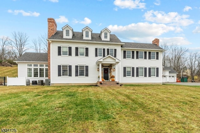 colonial-style house featuring a front lawn