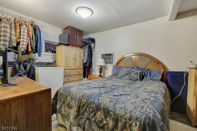 bedroom featuring a wall unit AC and washer / clothes dryer