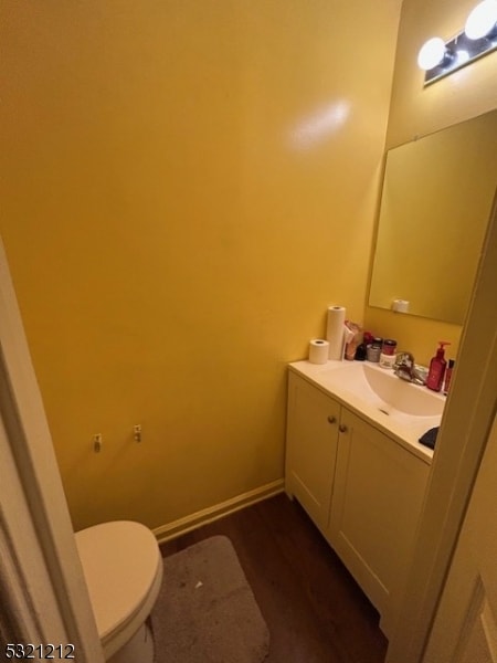 bathroom featuring vanity, toilet, and hardwood / wood-style floors