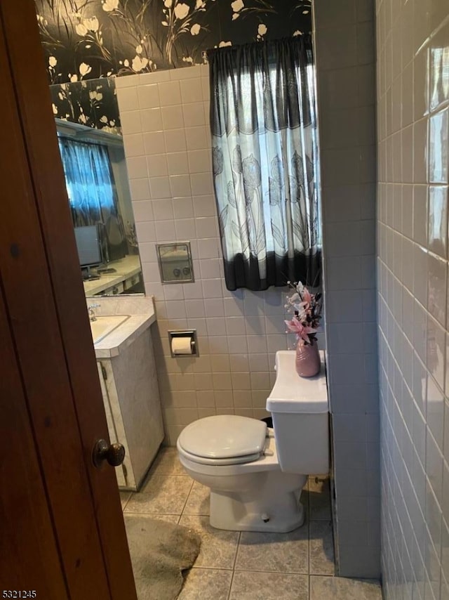 bathroom featuring tile patterned floors, tile walls, and toilet